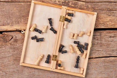 Opened box with checkers.Checkered box with checkers on wooden background.