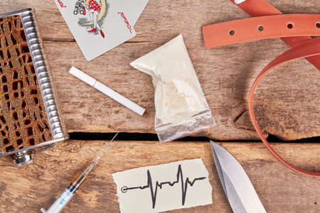 Alcoholism and narcotics background. Drugs, belt, cards, alcohol, cigarette, top view.の写真素材