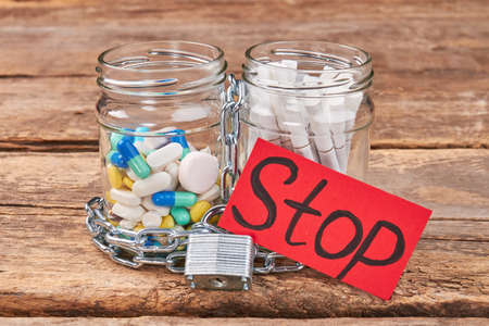 Cigarettes and pills, paper message. Jars with pills and cigarettes, metallic chain, padlock,...