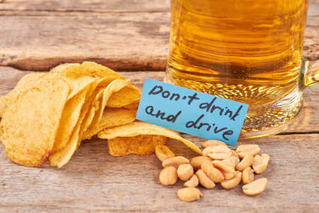 Do not drink and drive concept. Beer background, paper message.