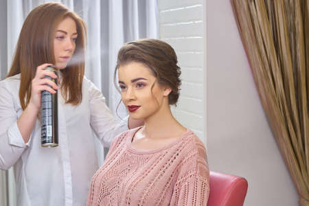 Stylist using hair spray. Customer of hairdressing salon. Top rated firm hold hairspray.