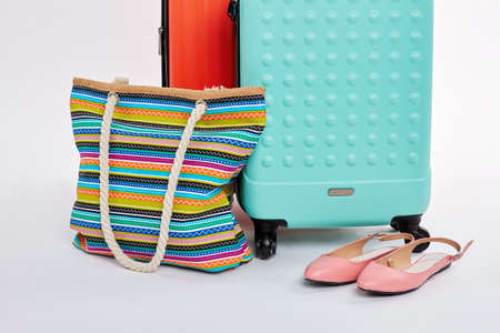 Pair of suitcases, handbag, sandals. Bright accessories for summer vacation.の写真素材