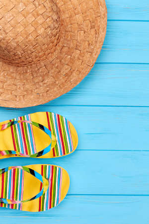 Straw hat, slippers close up. Beach accessories in left border.