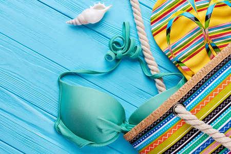 Close up of fashion handbag with slippers. Stylish beach accessories on vintage board.の写真素材