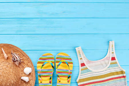 Female beach clothing on bottom border. Blue wooden surface and summer accessories.の写真素材