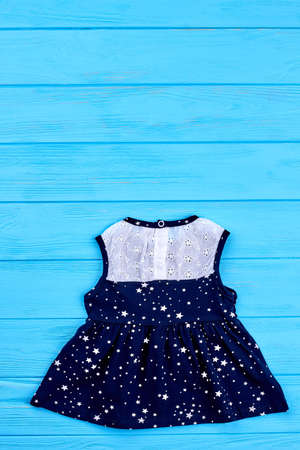 Casual dress for newborn, copy space. Fashionable white and blue summer dress on wooden background. Infant girl summer outfit.の写真素材
