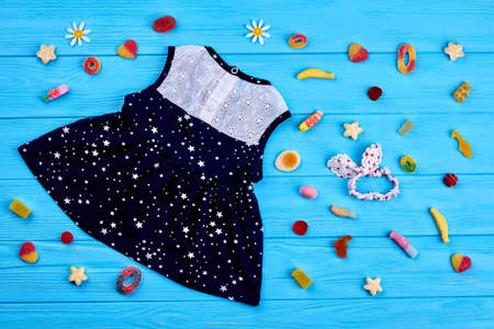 Stylish high quality children clothing. Cute baby-girl summer blue and white dress, hairband, sweets. Kids summer fashion background.の写真素材