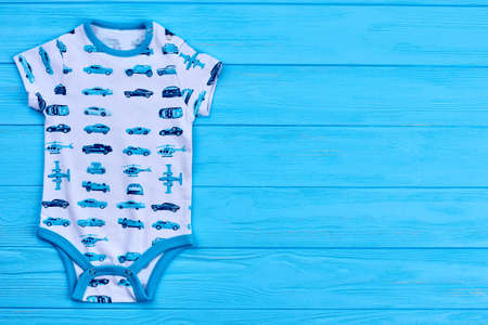 Quality brand baby boy bodysuit. Newborn baby boy printed romper and copy space, blue wooden background.の写真素材