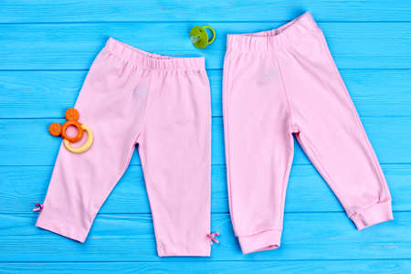 Collection of trendy stretch baby leggings. Modern colored pants for baby-girl, pacifier. Cotton pink baby-girl summer capri, accessories. Natural kids clothes.の写真素材