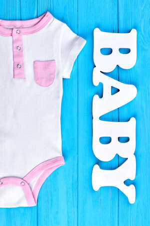 Baby-girl brand organic bodysuit. Vertical image of of short sleeve baby romper. Infant baby summer fashion background.の写真素材