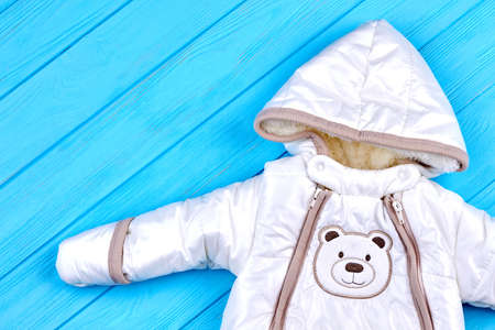 Unisex baby winter overall. Newborn boys or girls down outerwear romper close up. Baby warm winter...