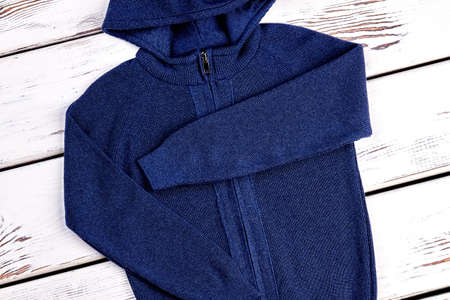 Casual wear hooded knitted sweater. Close up of new folded cardigan with hoodie for little boys.の写真素材