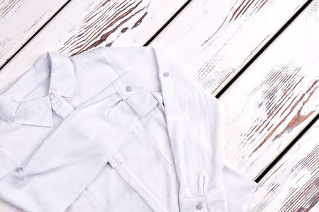 New white blouse for school girl. Girls cotton elegant white blouse for school wear on old wooden background. Classical white blouse for school girls on sale.の写真素材