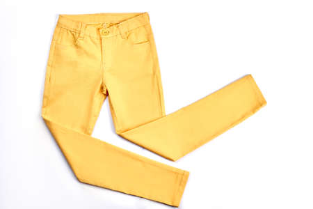 Girls beautiful yellow skinny trousers. Modern pockets yellow trousers for teenagers isolated on white background. Youth summer fashion apparel.の写真素材