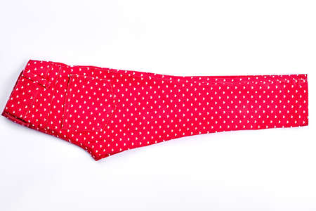 Female red in heart print trousers. Girls new red cotton jeans with a pattern of small white hearts, isolated on white background.の写真素材