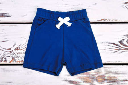 Baby boy dark blue cotton shorts. Childrens summer shorts on white wooden background. Brand kids apparel on sale.の写真素材