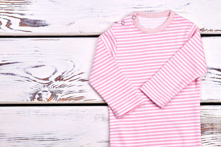 Baby-girl new organic romper. High quality cotton striped bodysuit for newborn baby-girl, old wooden background.の写真素材