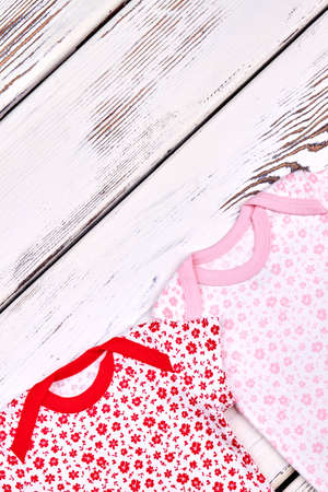 Baby-girl cute summer clothes. Newborn baby-girl set of soft patterned summer rompers on white...