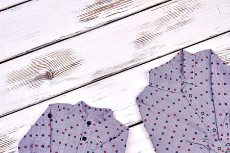 Boys new shirts on wooden background. Collection of brand clothing for toddler boys. Set of kids fashion apparel and copy space.の写真素材