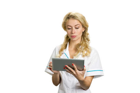 Portrait of young nurse with computer tablet. Pretty blond female doctor holding computer tablet on white background.の写真素材