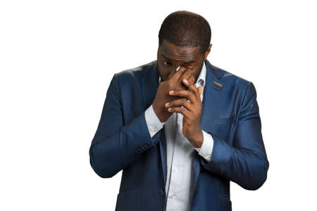 Business man wipe his eye. Afro american young manager in dark blue suit wipe eye with white napkin.の写真素材