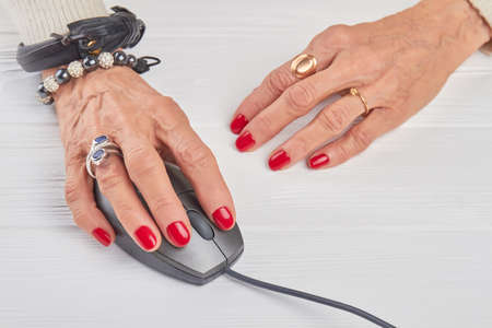 Female hands working with computer mouse. Businesswoman hands with luxury jewelry using computer mouse, white background.の写真素材