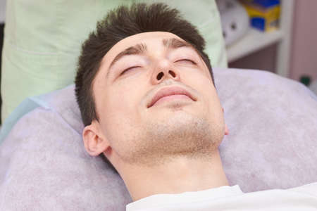 Young man with eyes closed. Guy in the hospital. Brain activity during sleep.の写真素材