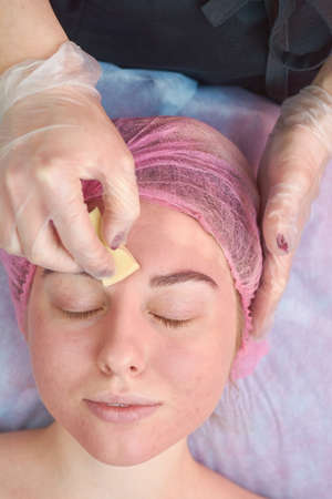 Hand applying foundation cream. Girl with eyes closed, cosmetology. Anti acne products reviews.の写真素材