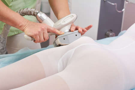 Vacuum roller massage, female body. Hands using lipomassage equipment.の写真素材
