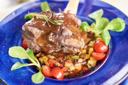 Lamb shank with vegetables ratatouille. Beutifully served with fresh vegetables appetizing lamb...