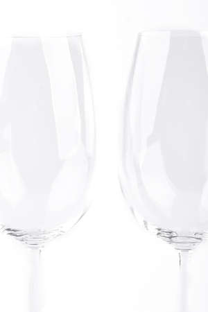 Empty wine glasses, cropped image. Transparent glasses for wine isolated on white background. Fragile and elegant tableware.の写真素材