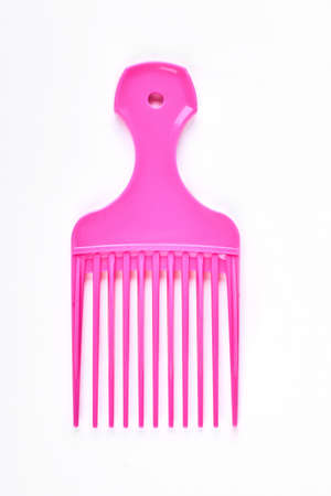 Pink professional afro comb. Hairdresser vivid color afro comb isolated on white background.の写真素材