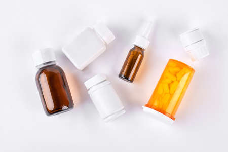 Bottles with medicine, top view. Set of vial bottles and pills on white background. Medicine, health care and pharmaceutical drugs concept.の写真素材