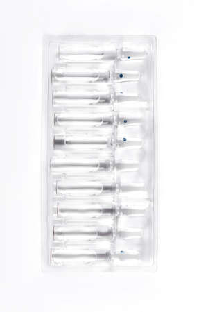 Medical ampoules for injections, top view. Raw of glass ampoules with liquid for injections, white background.の写真素材