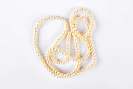 Wedding jewelry on white background. Pearl necklace isolated on white background, top view. Fashion and beauty concept.の写真素材