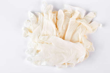 Pile of white medical gloves. Heap of thin latex medical gloves isolated on white background. Medicine and health care concept.の写真素材
