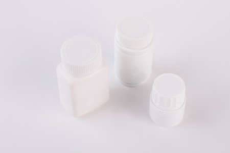 Three plastic bottles for pills. Blank medicine bottles isolated on white background.の写真素材