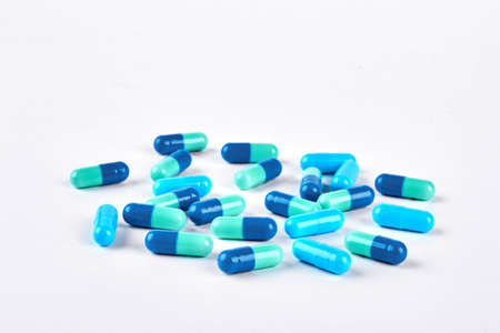 Pile of blue pills on white background. Blue medical capules on white background. Medicine and healthcare concept.の写真素材