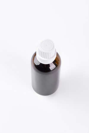 Medical bottle of brown color. Amber bottle with white cap isolated on white background, top view.の写真素材