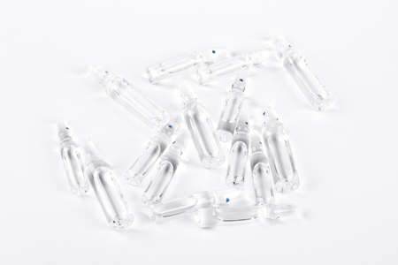 Set of transparent glass ampoules with liquid. Break-seal glass ampoules with medicine on white...