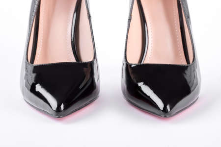 Black lacquered high heels close up. Pair of luxury high-heeled shoes isolated on white background. Woman trendy outfit.の写真素材