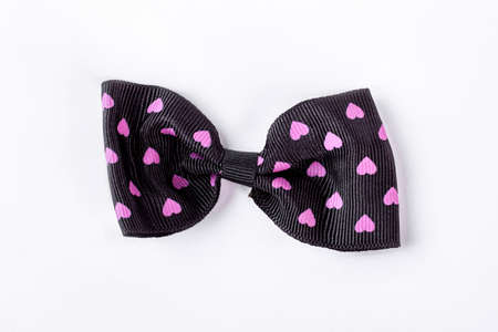 Black patterned bow tie on white background. Hair bow with a pattern of hearts isolated on white background. Ggirls adorable hair accessory.の写真素材