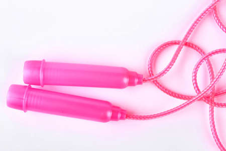Plastic skipping rope, top view. Pink jump rope isolated on white background. Sport equipment on sale.の写真素材