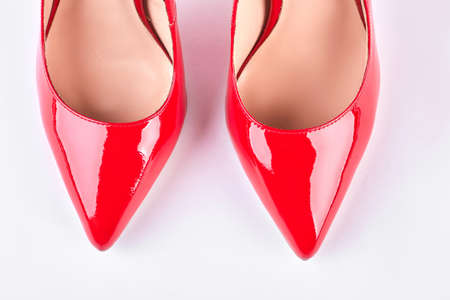 Woman new red lacquered shoes. Female red leather shoes isolated on white background. Elegant woman shoes on sale.の写真素材