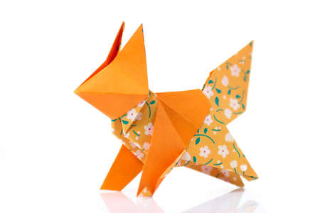 Fox origami model on white. Folded orange and patterned paper. Artwork of talented child.の写真素材