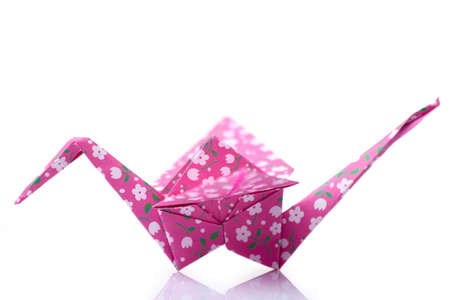 Pink orizuru figurine on white. Classic Japanese design of paper crane. Origami crafting, art lessons, culture.の写真素材