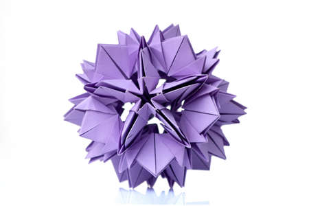 Violet flower origami on white. Wonderful figurine made of folded colorful paper. Piece of craftsmanship.の写真素材
