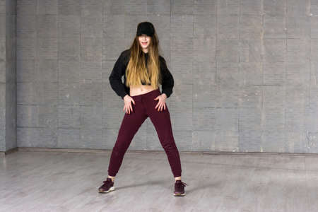 Casual girl dancer posing on grey background. Young caucasian modern style girl dancing contemporary dance in studio. School of modern dance.の写真素材