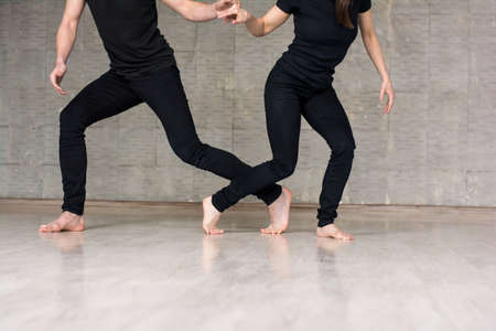 Young couple of dancers in movement. Talented young man and woman practicing dance element on studio background, cropped image.の写真素材