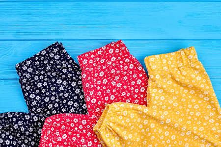 Trendy natural baby trousers close up. Organic pants in vintage print for baby girls lying on wooden...